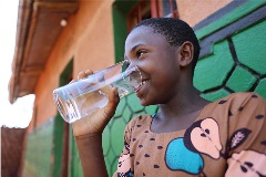 As a little brother to a sponsored child, Emmanuel and his community benefit from clean drinking water supplied by a World Vision tap near their home in Kisaro, Rwanda.